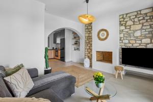 a living room with a couch and a tv at Juniper View in Aspro Chorio Paros