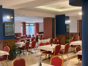 jadalnia z białymi stołami i krzesłami w obiekcie Hotel Continental w mieście Krynica Morska