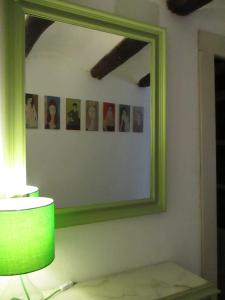 a mirror with a green frame on a wall at Casa Tuerta in Alcalá de Moncayo