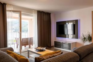 a living room with a couch and a tv at Beachfront villa with private pool in Vela Luka in Vela Luka