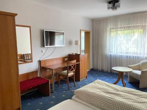 a hotel room with a desk and a bedroom at Gästehaus Café Ruff in Happurg