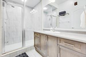 a white bathroom with a shower and a sink at spacious 3 bedroom space in Markham +30 photos