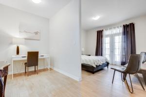 a white room with a bed and a desk and chairs at spacious 3 bedroom space in Markham