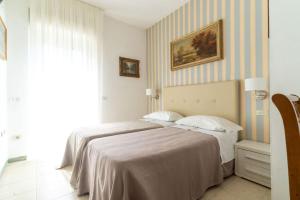 a bedroom with a bed and a painting on the wall at Hotel Ariella in Milano Marittima