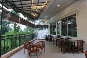 a restaurant with tables and chairs on a balcony at Zam Hotel By Pavotel in Kedungbadak