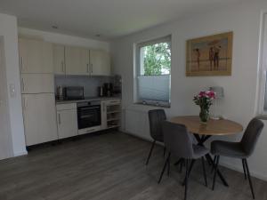 a kitchen with a table and chairs and a table and a window at Ferienpark Buntspecht in Pruchten