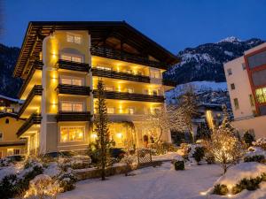 a large building with lights on in the snow at MÜHLBACHER - inklusive kostenfreiem Eintritt in die Alpentherme in Bad Hofgastein