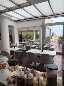 a cafeteria with tables and chairs with pastries on them at Boutique Hotel Bali in Lido di Jesolo
