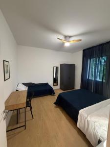 a bedroom with two beds and a table and a ceiling fan at A CA' da 8 e Jacky in Casalecchio di Reno