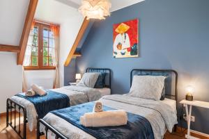 two beds in a room with blue walls at L'instant présent in Hautot-lʼAuvray