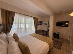 a bedroom with a large bed and a large window at Rebetiko Hotel in Alaçatı