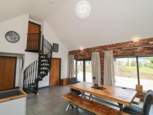 a dining room with a wooden table and stairs at The Croft, Home Farm in Ripley