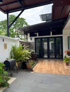 a house with a wooden floor and a patio at Permas Jaya Corner Homestay -Event -Party -TablePool -Karaoke -BBQ in Johor Bahru