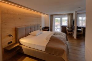 ein Schlafzimmer mit einem großen Bett und einer Holzwand in der Unterkunft Hotel Leimer Bräu in Lenzing + 45 Fotos