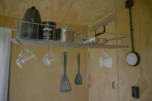 a kitchen with utensils hanging from a shelf at De IJsvogel in Wijdewormer +37 photos