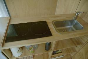 a kitchen counter with a sink in a cabinet at De IJsvogel in Wijdewormer
