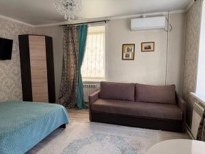 a living room with a couch and a bed at Happy House in Karagandy