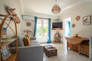 a living room with a couch and a table at VILLA LES SALINES Maison de Vacances au Grau du Roi in Le Grau-du-Roi