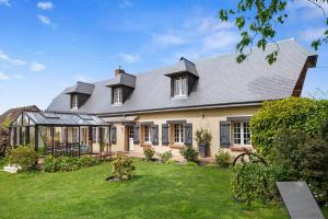 an exterior view of a house with a garden at L'instant présent in Hautot-lʼAuvray
