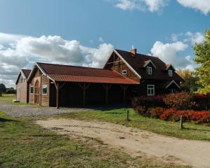 a large wooden house with a gambrel roof at agroOBERIBA in Płatkownica