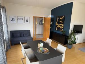 a living room with a black table and chairs at Penthouse Seeblick Wohnung 86 qm KLIMATISIERT in Friedrichshafen