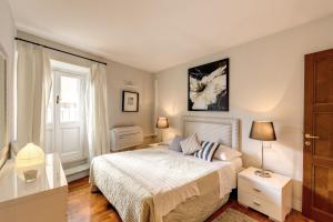 a white bedroom with a bed and a window at Appartamento con vista sul Vittoriano in Rome