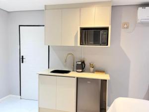 a small kitchen with a sink and a microwave at Zabo Guesthouse in Middelburg