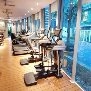 a gym with a row of treadmills and a pool at vortex klcc by IOI HOME management in Kuala Lumpur