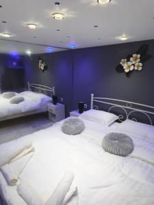 two beds in a room with purple walls at Giorgos Suite - Jacuzzi Hideaway in Lydia, Kavala in Lidia +28 photos