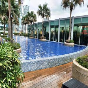 a large swimming pool in a building with palm trees at vortex klcc by IOI HOME management in Kuala Lumpur