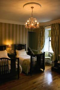 a bedroom with two beds and a chandelier at Rathaspeck Manor B&B in Wexford