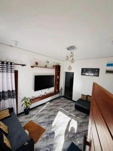 a living room with a large flat screen tv at Taniya Sunview - Villa in Nuwara Eliya