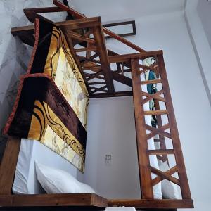 a wooden bunk bed in a white room at Taniya Sunview - Villa in Nuwara Eliya