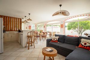 a living room with a couch and a kitchen at VILLA LES SALINES Maison de Vacances au Grau du Roi in Le Grau-du-Roi