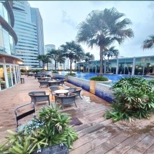 a courtyard with tables and chairs and palm trees at vortex klcc by IOI HOME management in Kuala Lumpur