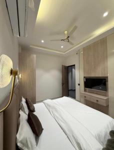 a bedroom with a large white bed and a television at Hotel sky inn in Jalandhar
