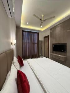 a bedroom with a large white bed with red pillows at Hotel sky inn in Jalandhar