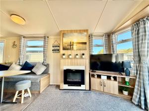 a living room with a tv and a fireplace at Dale 12 in Burgh Island