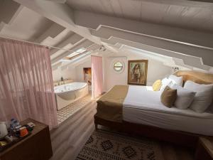 a bedroom with a large bed and a bath tub at Rebetiko Hotel in Alaçatı +227 photos