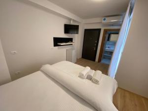 a bedroom with a white bed with two towels at Venecia gold in Struga