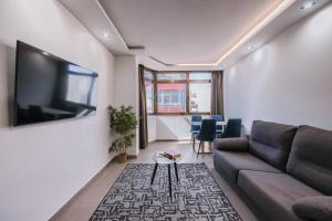 a living room with a couch and a flat screen tv at Poem Suites by Airnest in Las Palmas de Gran Canaria