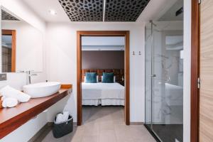 a bathroom with a tub and a sink and a bed at Poem Suites by Airnest in Las Palmas de Gran Canaria