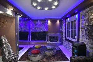 a living room with purple lighting and a couch and a tv at Eleni De Lux - Indoor Jacuzzi Residence in Lydia in Lidia