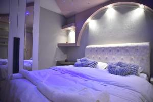 a bedroom with a large bed with purple lighting at Eleni De Lux - Indoor Jacuzzi Residence in Lydia in Lidia +35 photos