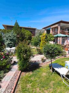 a house with a garden with a bench in the yard at Eleni De Lux - Indoor Jacuzzi Residence in Lydia in Lidia
