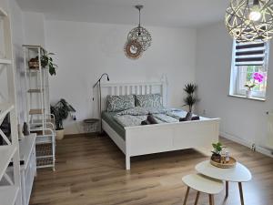 ein Schlafzimmer mit einem weißen Bett und einem Tisch in der Unterkunft Villa Dacha in Niederwurschnitz