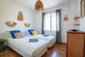 two beds in a room with white walls at VILLA LES SALINES Maison de Vacances au Grau du Roi in Le Grau-du-Roi