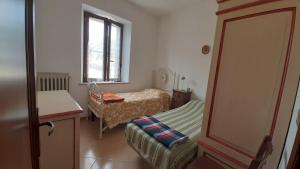 a small bedroom with a bed and a window at la buca delL'IStrice in Monteriggioni
