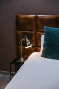 a bedroom with a bed with a lamp on a table at Poem Suites by Airnest in Las Palmas de Gran Canaria +56 photos
