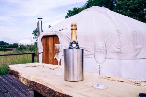 a bottle of champagne on a table with two glasses at Bunkers Hill Farm in Bramfield